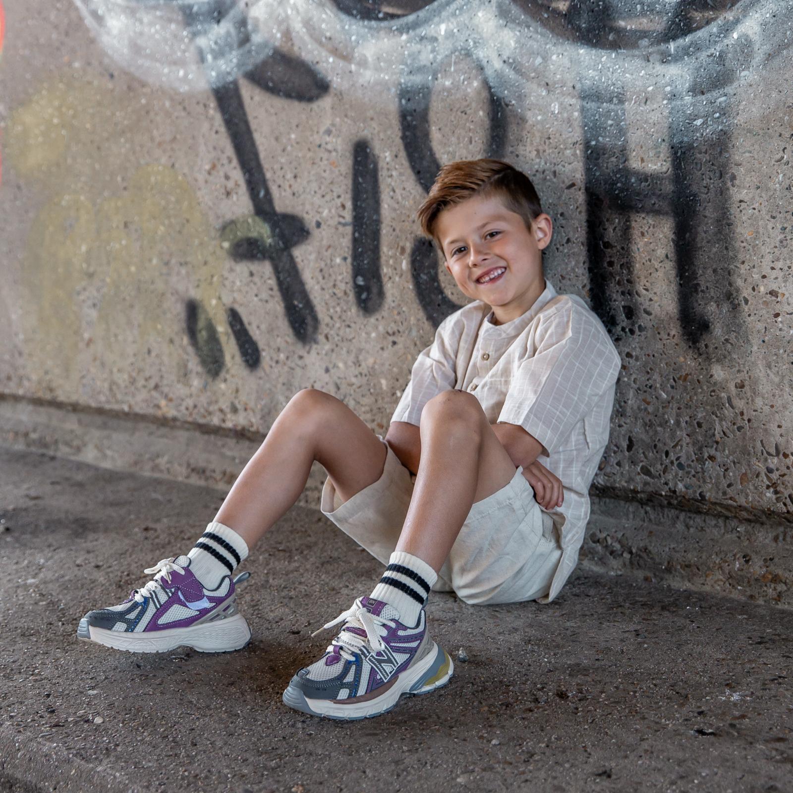 Zittend jongetje met Twistz Purple kindersneakers van Lilpataz aan de voeten – comfortabele en trendy sneakers voor kinderen